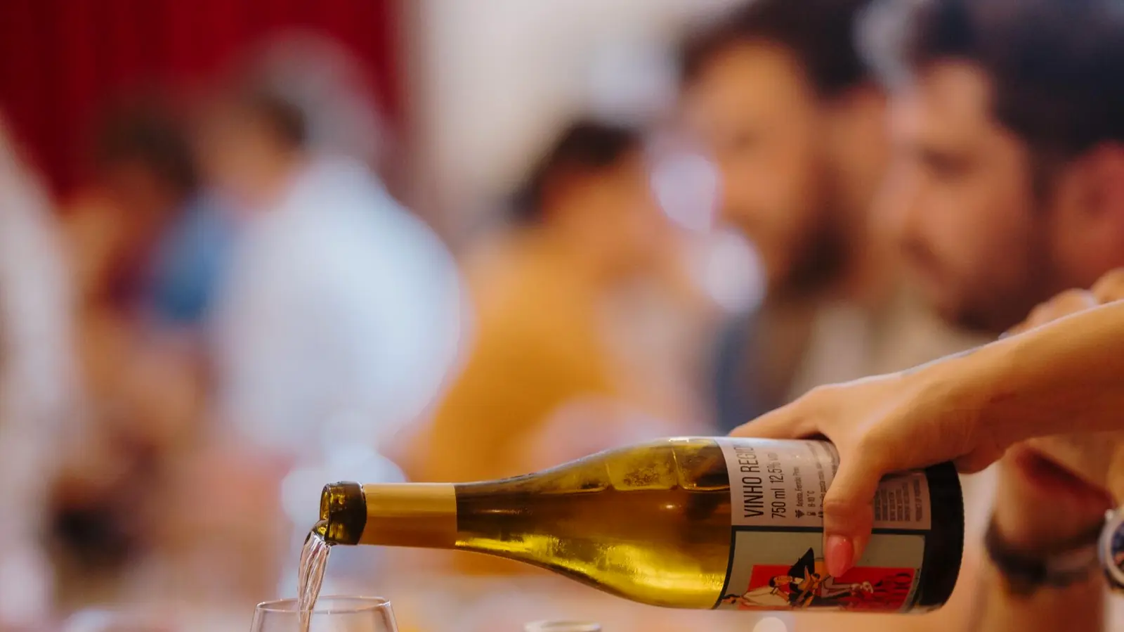 Weißwein wird beim Abendessen am Tisch eingeschenkt