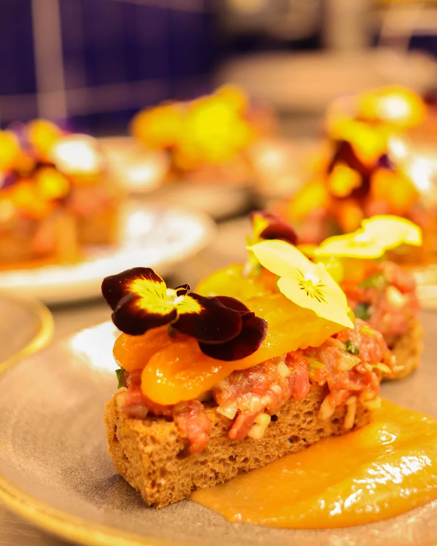Tártaro de carne sobre pão, com flores comestíveis, no Fado ao Carmo Alfama